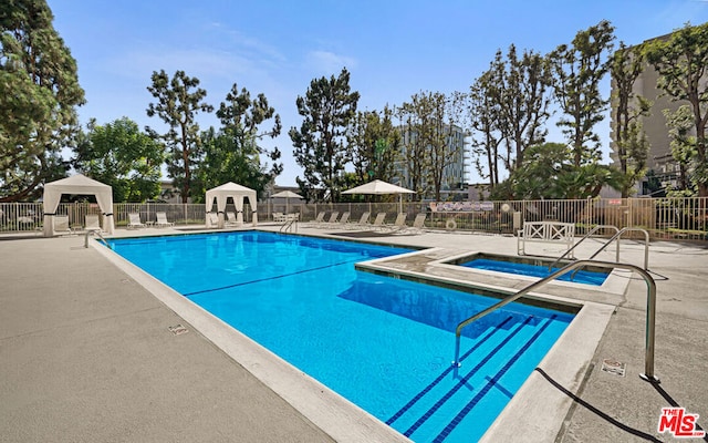 view of swimming pool with a gazebo, a community hot tub, and a patio area