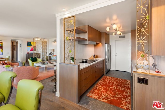 kitchen with black electric cooktop, backsplash, stainless steel fridge, and dark hardwood / wood-style floors