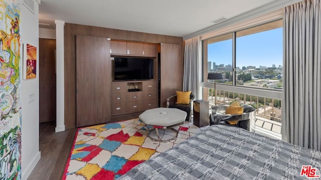 bedroom featuring expansive windows and dark hardwood / wood-style floors