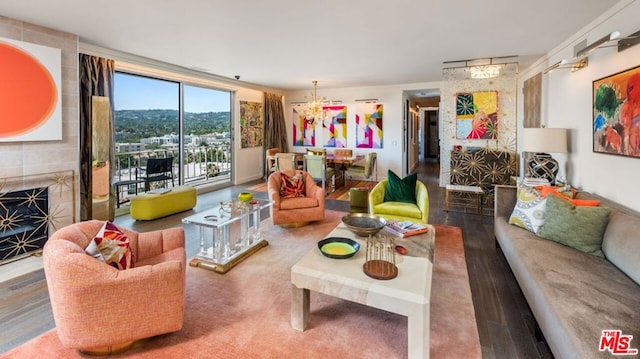 living room featuring a large fireplace, wood-type flooring, and a notable chandelier