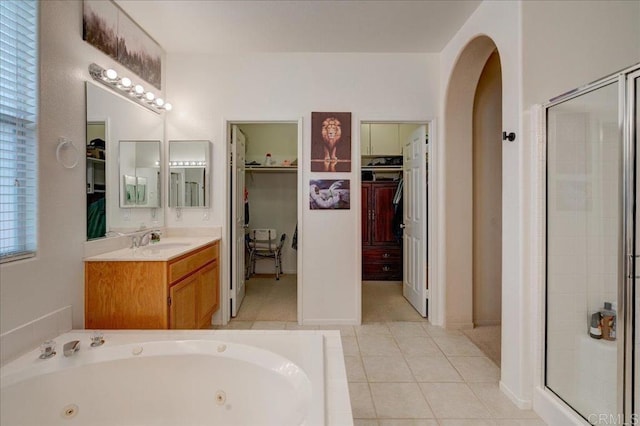 bathroom featuring tile patterned flooring, plus walk in shower, and vanity