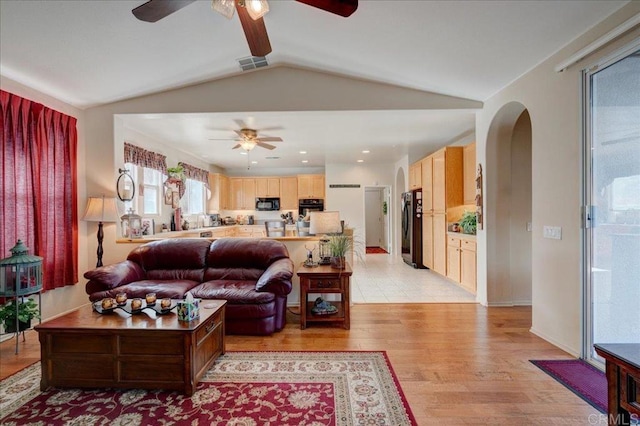 living room with vaulted ceiling, light hardwood / wood-style floors, and ceiling fan