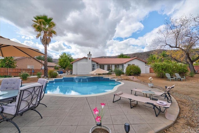 view of pool featuring a patio and an in ground hot tub