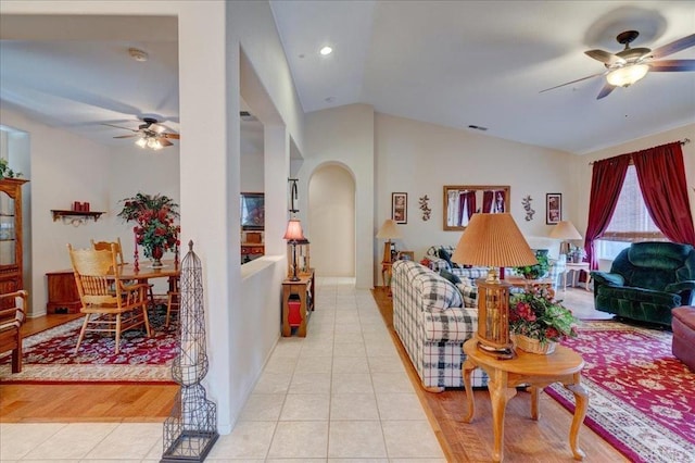 tiled living room with ceiling fan and lofted ceiling