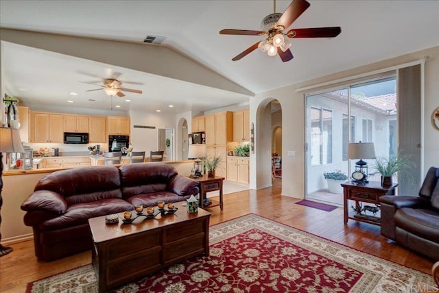 living room with ceiling fan, lofted ceiling, and light hardwood / wood-style floors