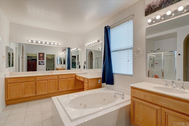 bathroom with tile patterned floors, vanity, and independent shower and bath