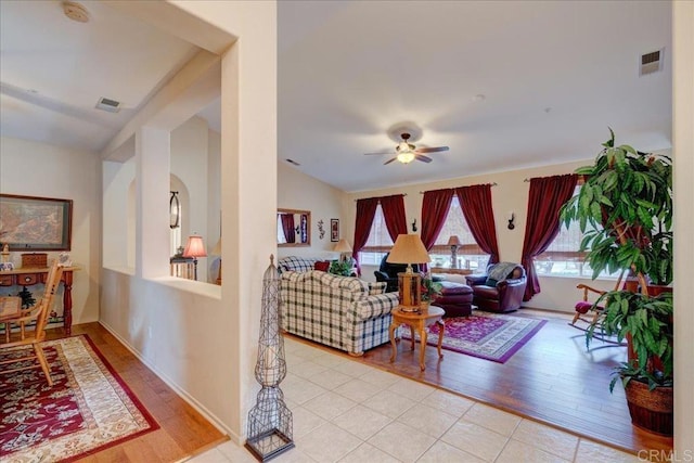 living room with lofted ceiling, ceiling fan, and light hardwood / wood-style floors