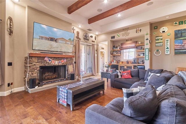 living room featuring hardwood / wood-style floors, beam ceiling, and a stone fireplace