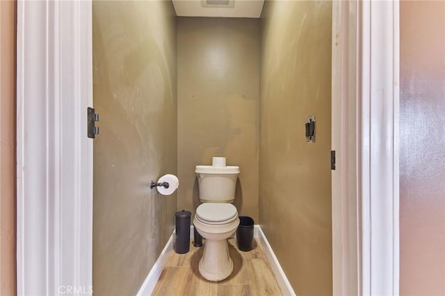 bathroom featuring hardwood / wood-style flooring and toilet