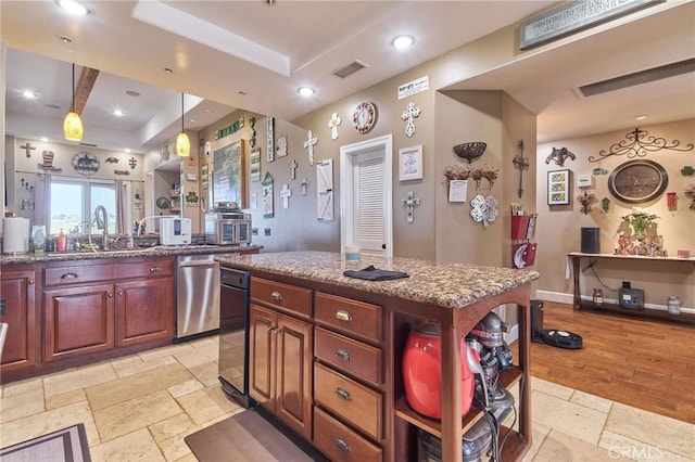 kitchen with pendant lighting, sink, a center island, a tray ceiling, and stainless steel dishwasher