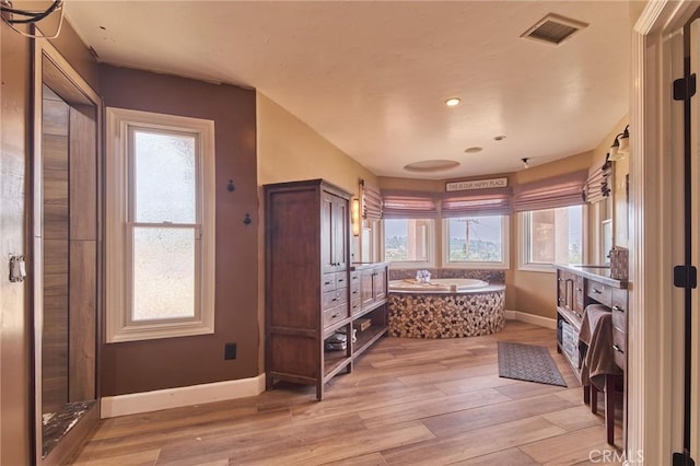 bathroom with hardwood / wood-style flooring and a tub