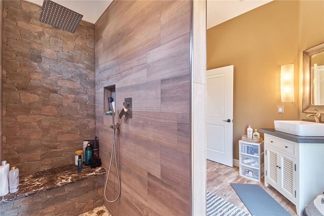 bathroom with vanity, wood-type flooring, and tiled shower