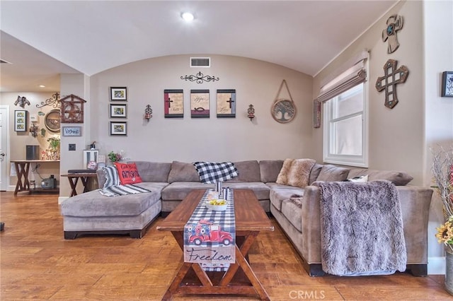 living room with hardwood / wood-style flooring and vaulted ceiling