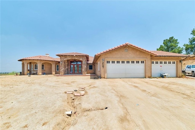 mediterranean / spanish-style home featuring a garage and french doors