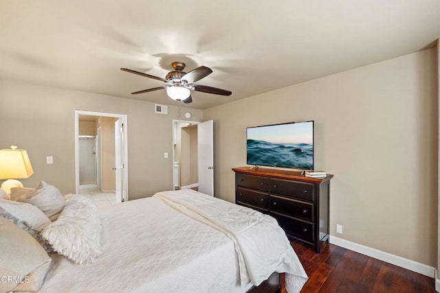 bedroom with dark wood-type flooring, ceiling fan, and ensuite bathroom