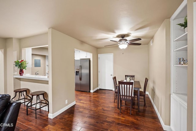 dining space featuring ceiling fan, electric panel, and dark hardwood / wood-style flooring