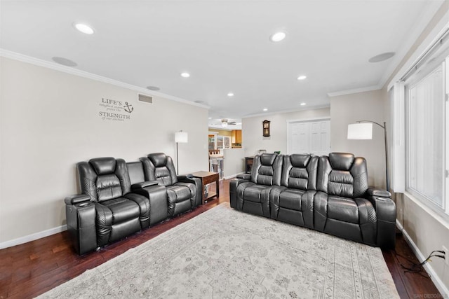 cinema room with dark hardwood / wood-style flooring, crown molding, and ceiling fan