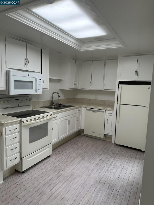 kitchen with white cabinetry, ornamental molding, sink, and white appliances