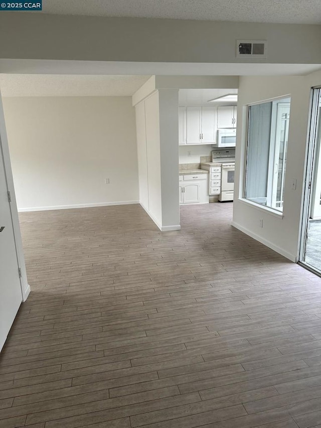 unfurnished living room featuring wood-type flooring and a textured ceiling