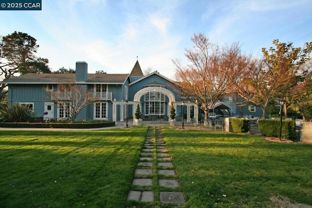 rear view of property featuring a lawn