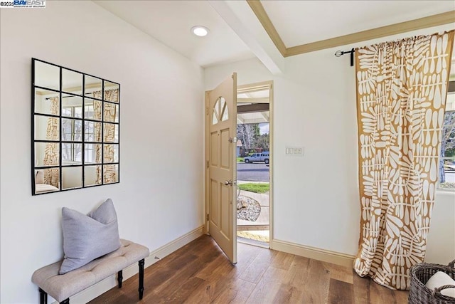 foyer with dark wood-type flooring and beamed ceiling