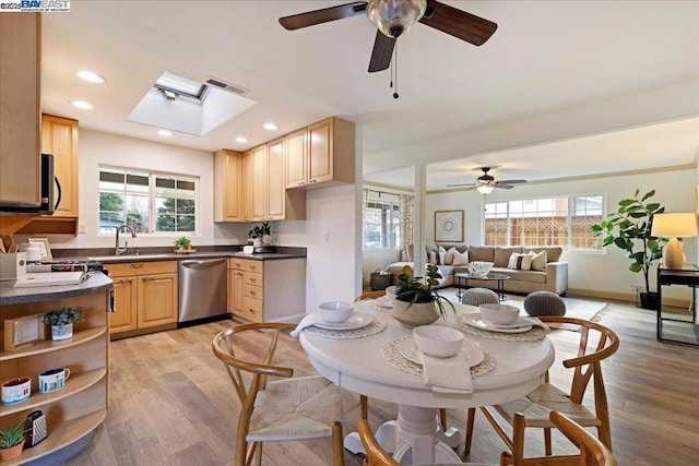 kitchen featuring dishwasher, light wood-type flooring, light brown cabinetry, and a skylight