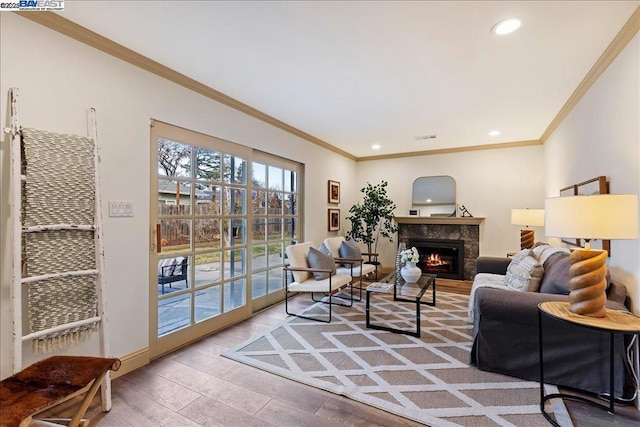 living room featuring hardwood / wood-style flooring, a fireplace, and ornamental molding