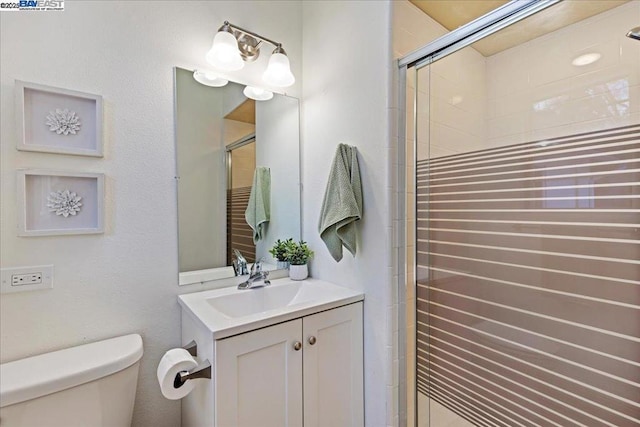 bathroom featuring vanity, toilet, and an enclosed shower