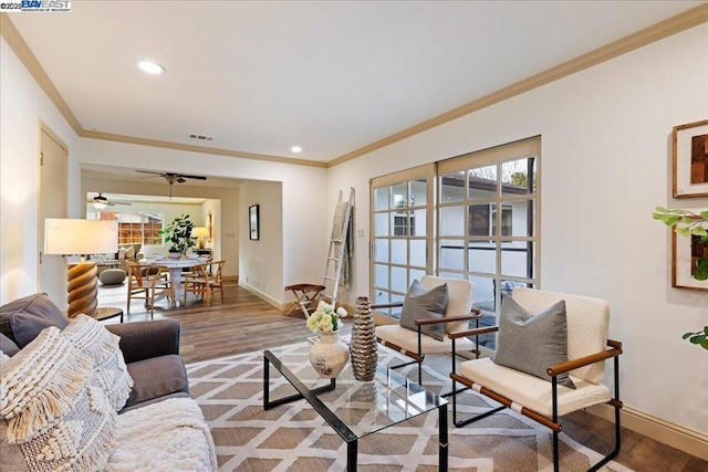 living room with crown molding, a healthy amount of sunlight, and hardwood / wood-style floors