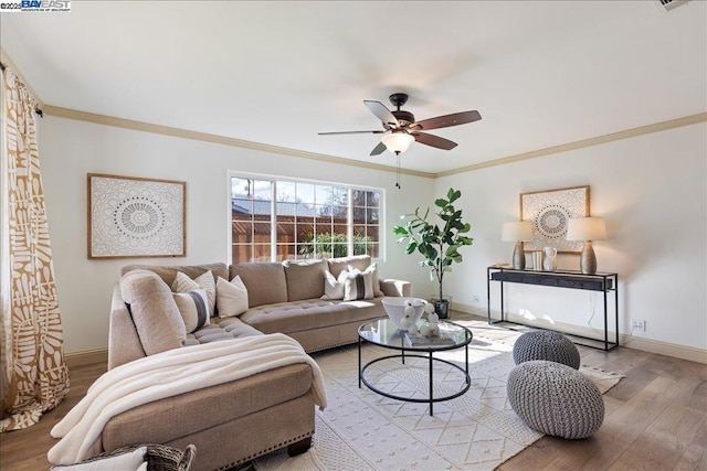 living room with ornamental molding, ceiling fan, and light hardwood / wood-style floors