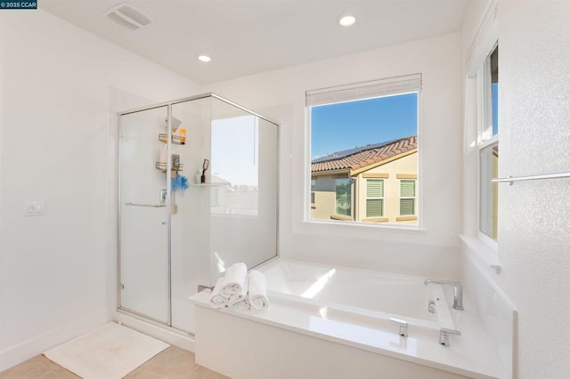 bathroom with tile patterned flooring and shower with separate bathtub