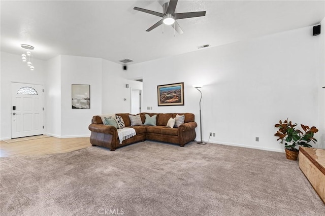 carpeted living room with ceiling fan