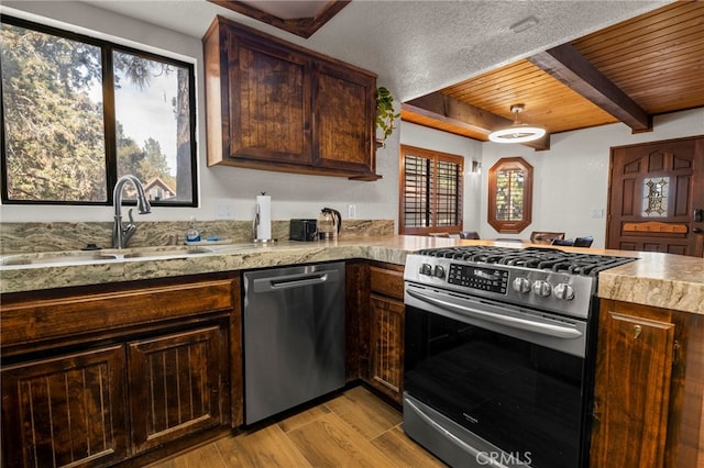 kitchen featuring beamed ceiling, dark brown cabinetry, light hardwood / wood-style floors, stainless steel appliances, and wooden ceiling