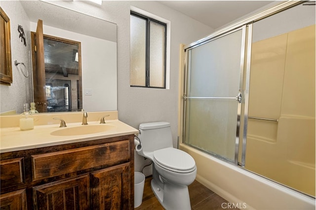 full bathroom with enclosed tub / shower combo, vanity, toilet, and wood-type flooring