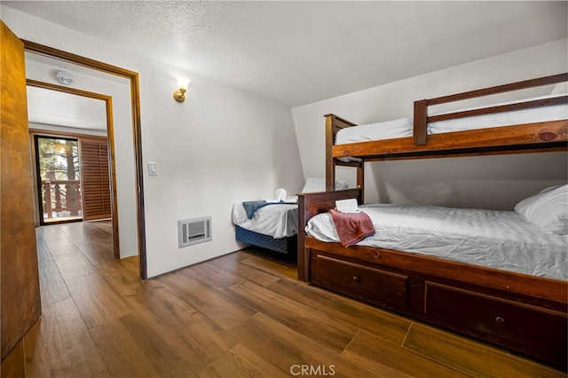 bedroom with dark hardwood / wood-style flooring and a textured ceiling