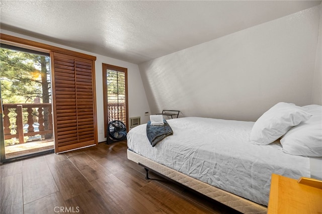 bedroom with dark hardwood / wood-style floors and a textured ceiling