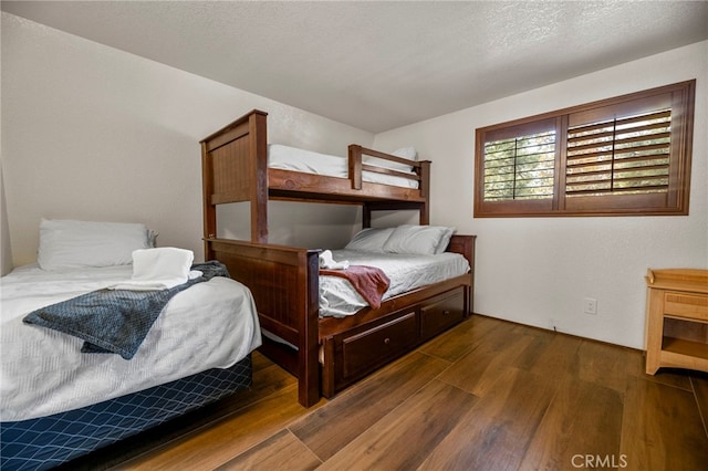 bedroom with dark hardwood / wood-style flooring and a textured ceiling