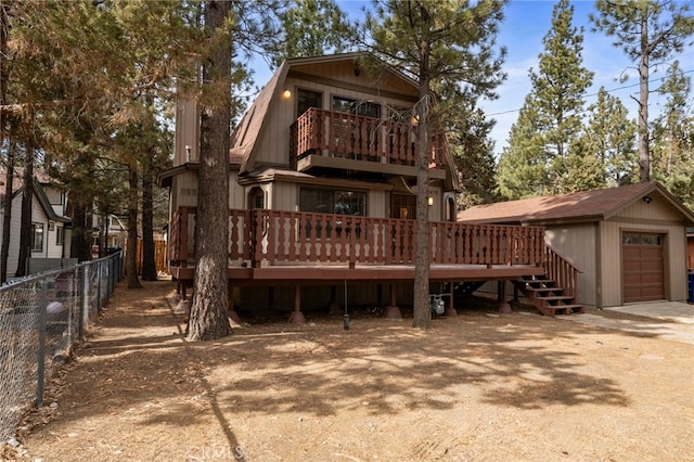 back of property with a garage, an outbuilding, and a deck