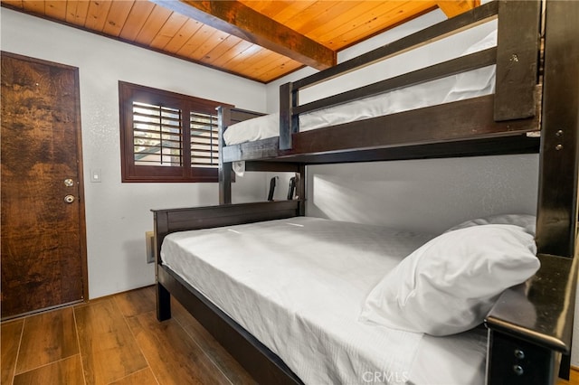 bedroom featuring hardwood / wood-style floors, wooden ceiling, and beam ceiling