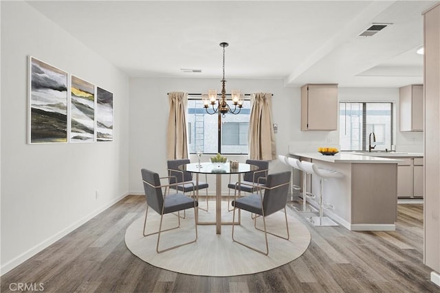 dining area featuring a healthy amount of sunlight, light hardwood / wood-style floors, and sink