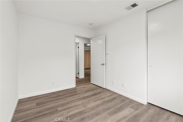 unfurnished bedroom with hardwood / wood-style floors and a closet