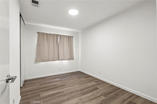 spare room featuring dark wood-type flooring