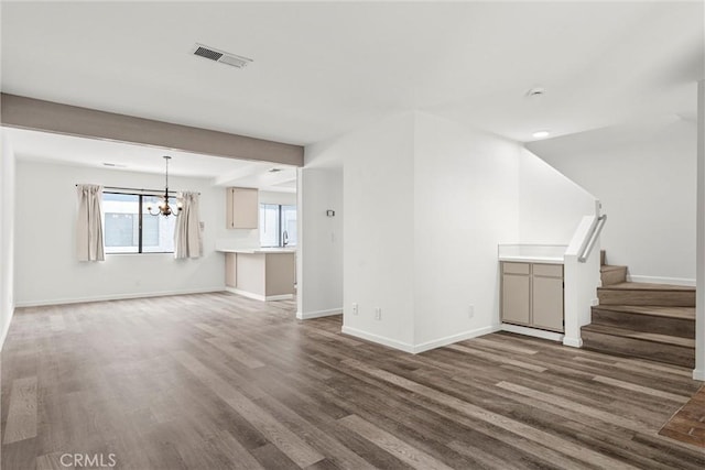 unfurnished living room featuring dark hardwood / wood-style flooring and a chandelier