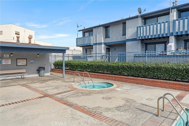 view of swimming pool featuring a hot tub and a patio