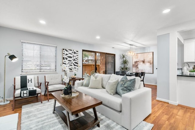 living room featuring sink and light hardwood / wood-style flooring