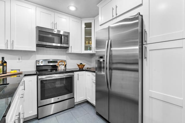 kitchen featuring tasteful backsplash, white cabinetry, and appliances with stainless steel finishes