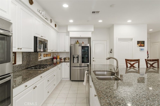 kitchen with stainless steel appliances, white cabinetry, and sink