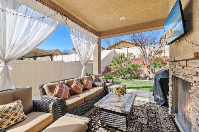 view of patio / terrace featuring a grill and an outdoor living space with a fireplace