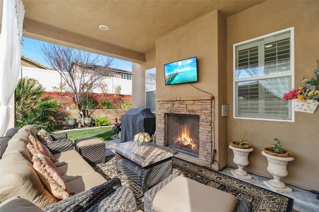 view of patio / terrace with an outdoor living space with a fireplace and area for grilling