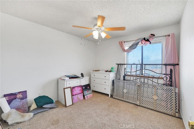 carpeted bedroom featuring ceiling fan and a textured ceiling